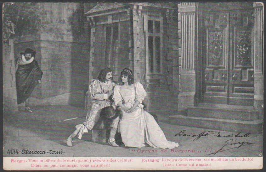 Postcard with scene from the play Cyrano de Bergerac. Roxane next to Christian as Cyrano hides.